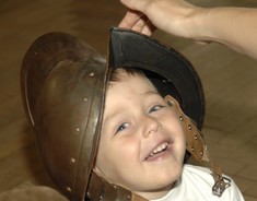 Ein lachendes Kind mit einem Ritterhelm.