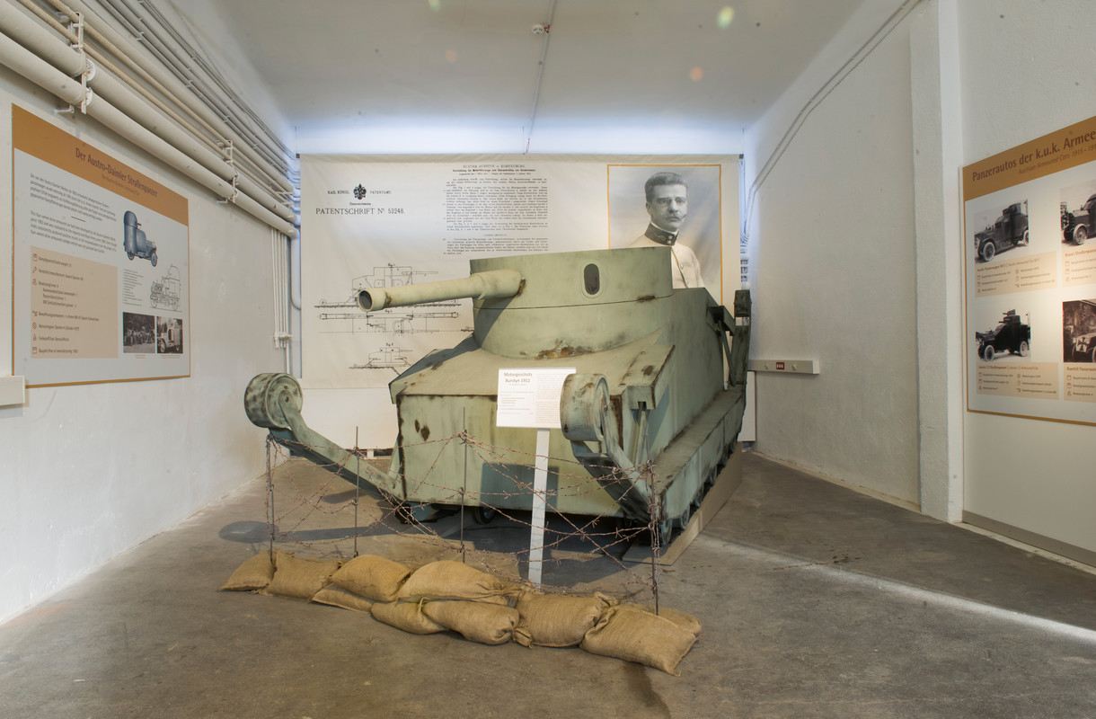Panzer im Ausstellungsraum, umgeben von Infotafeln.