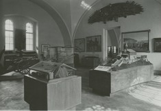 Schwarz-Weiß-Foto mit Schaukästen und Vitrinen im Ausstellungsraum.