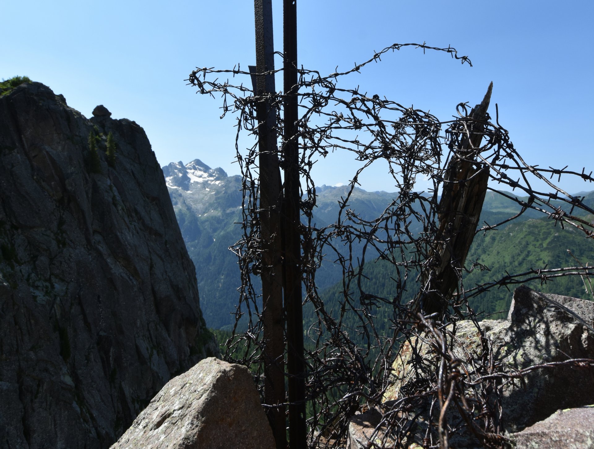   Auf diesem Bild sieht man ein Bild eines Abschnittes eines Stacheldrahtzaunes hoch auf den Bergen, erstellt von Renato Orsingher.