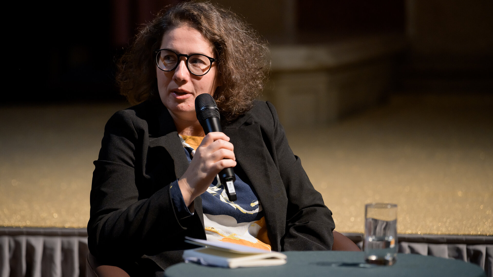 Auf diesem Bild sieht man die Künstlerin in ein Mikrophon sprechen