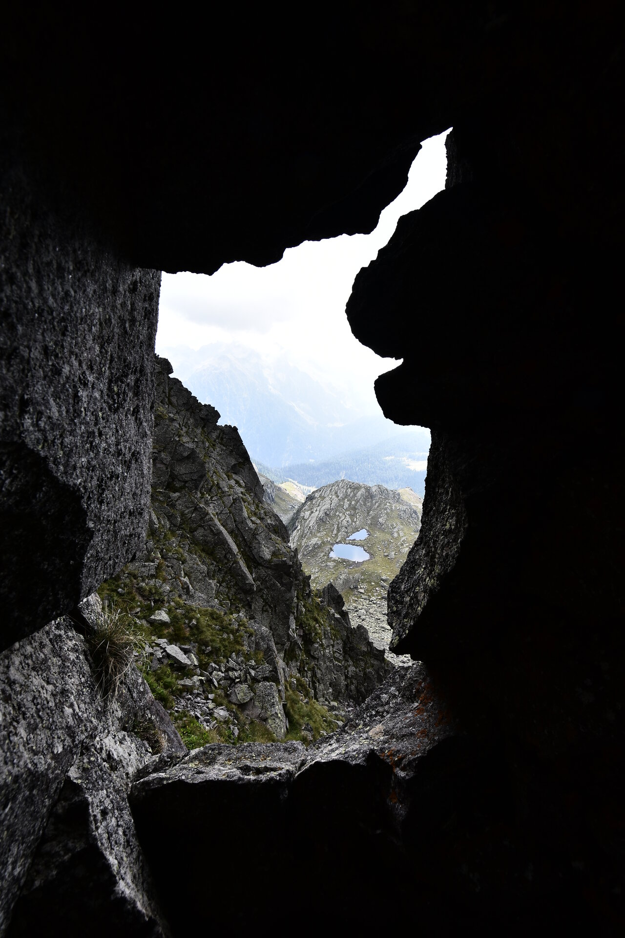 Auf diesem Bild sieht man einen Stollen von innen, mit Blick auf einen bewölkten Himmel 