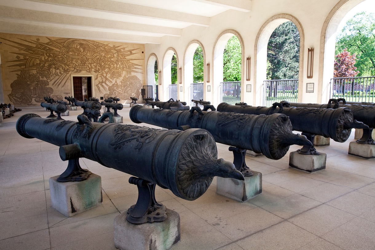 Auf dem Bild ist eine beeindruckende Sammlung von Geschützrohren in der Artilleriehalle zu sehen. Die Halle ist geräumig und gut beleuchtet, was den Blick auf die zahlreichen historischen Geschützrohre ermöglicht, die sorgfältig arrangiert sind. Jedes Geschützrohr unterscheidet sich in Größe, Form und Verzierungen, was die Vielfalt und Entwicklung der Artillerie im Laufe der Jahrhunderte verdeutlicht.